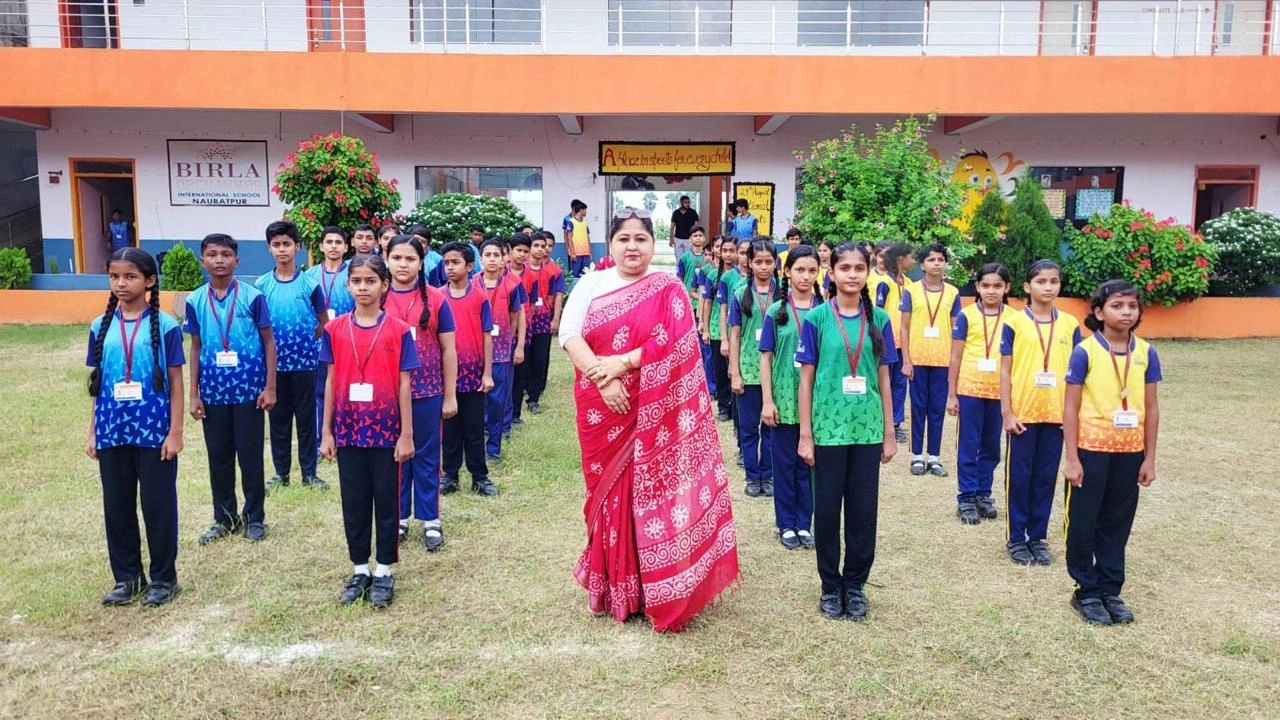 Students representing four school houses with an educator on the BOMIS Naubatpur campus