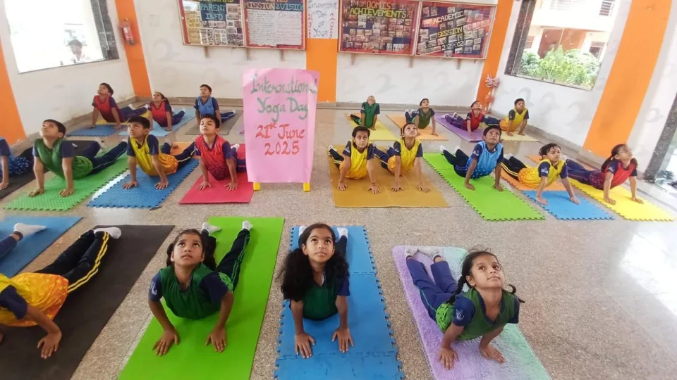 Primary students practising yoga in the school atrium at BOMIS Naubatpur